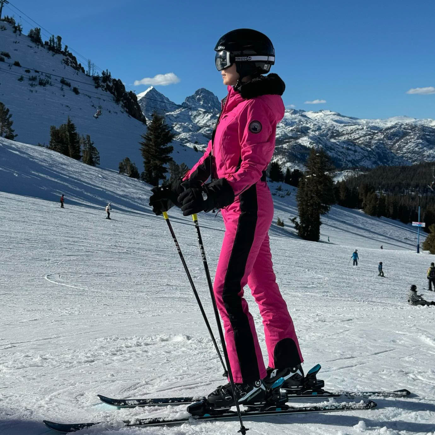 Les Odettes women's classic faux fur one-piece ski suit with hood and full front zipper, designed for winter skiing.