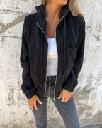 Les Odettes Cynthia™ hooded zip jacket with front pockets, black fabric, and adjustable drawstrings on the hood.