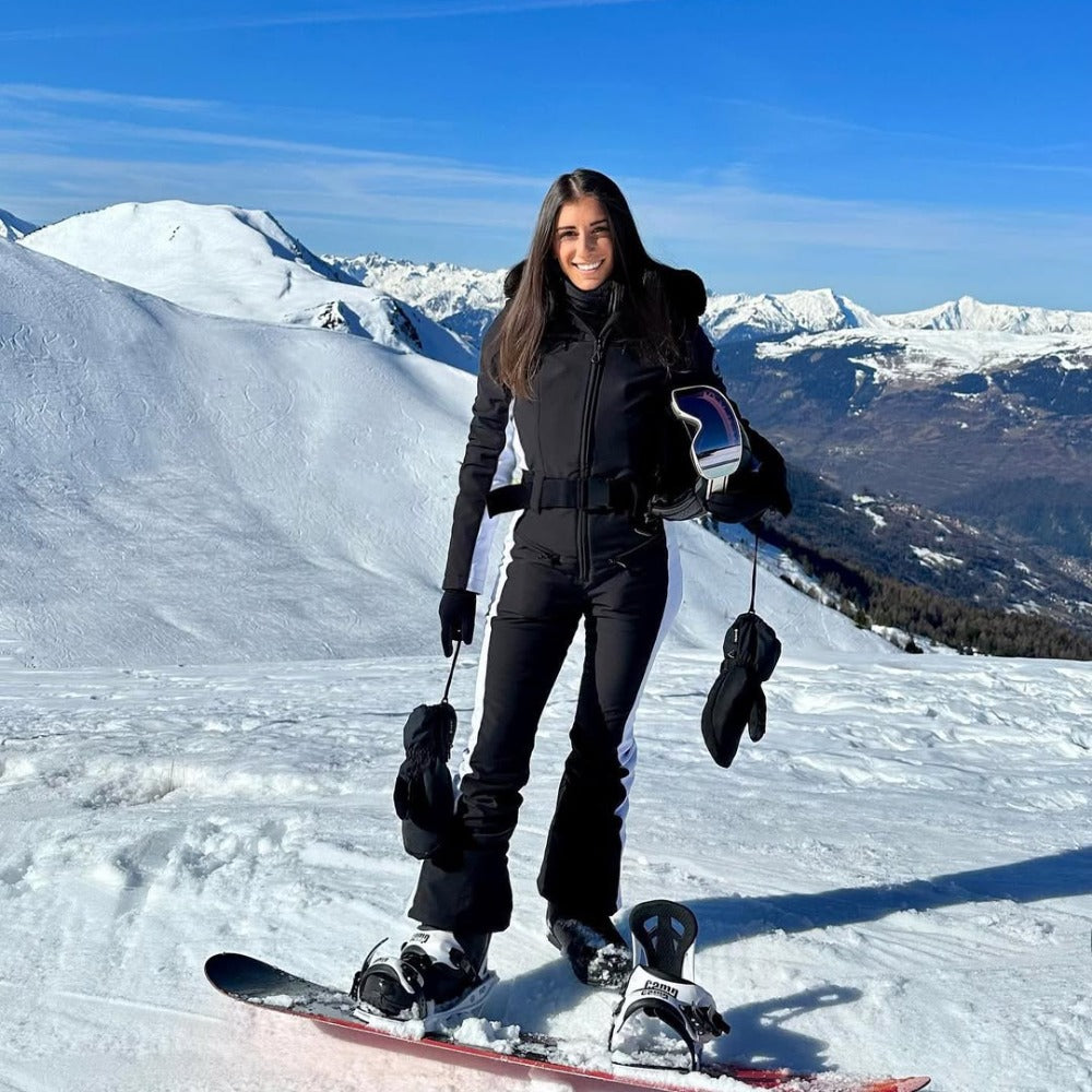 Les Odettes women's classic faux fur one-piece ski suit with hood, designed for warmth and style on the slopes.