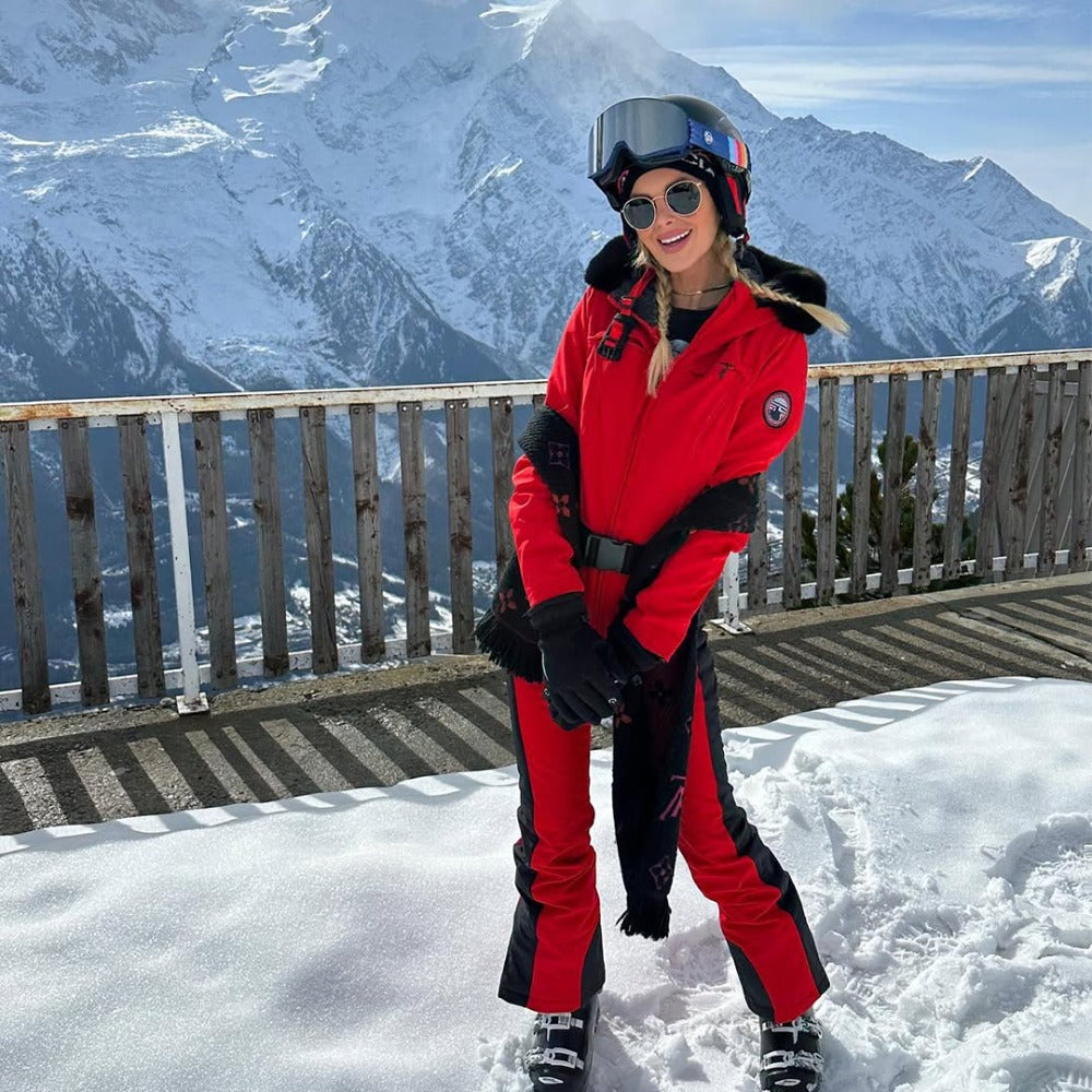 Les Odettes women's classic faux fur one-piece ski suit with hood, designed for warmth and style on the slopes.