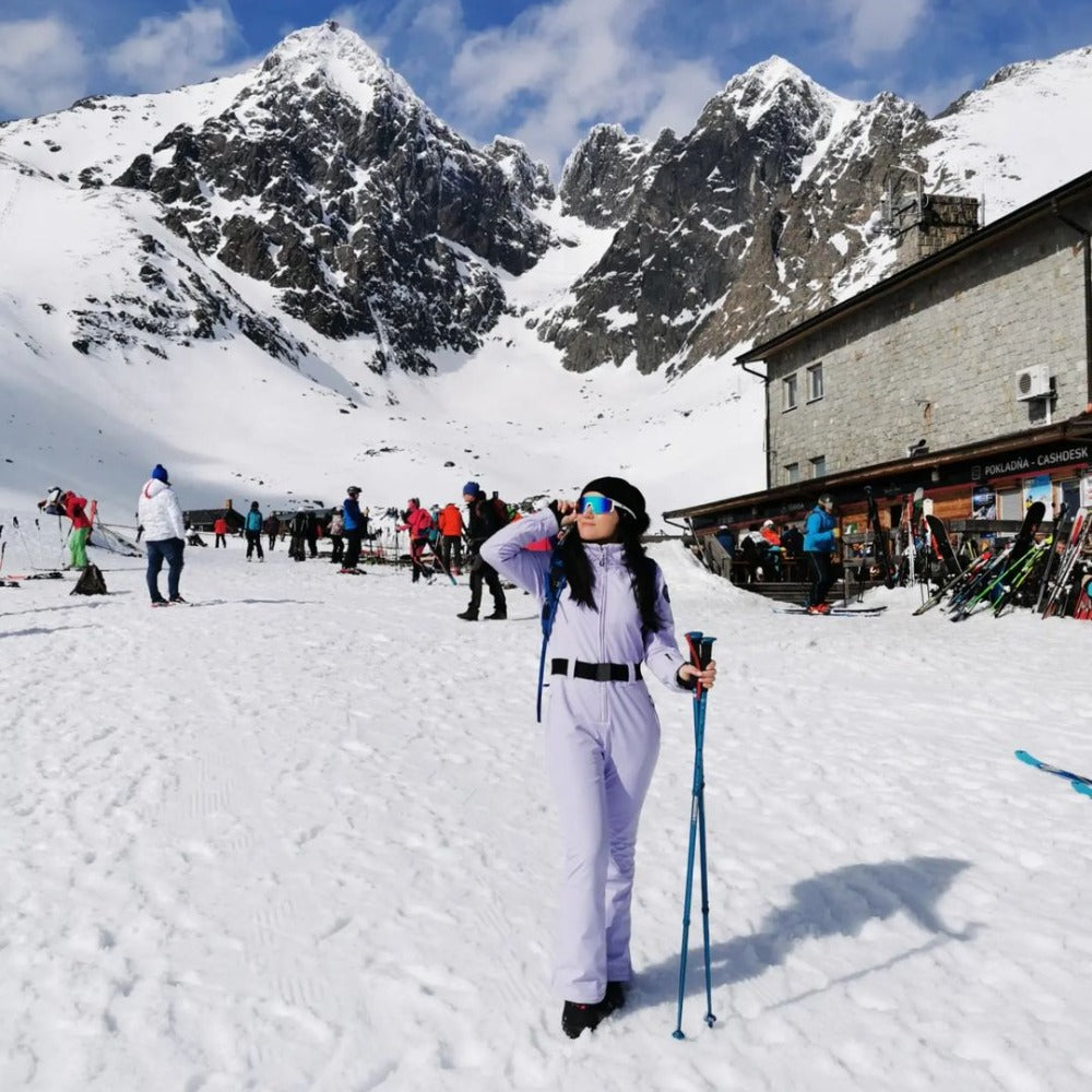 Les Odettes women's classic faux fur one-piece ski suit with a sleek design and cozy fur trim, ideal for winter sports.