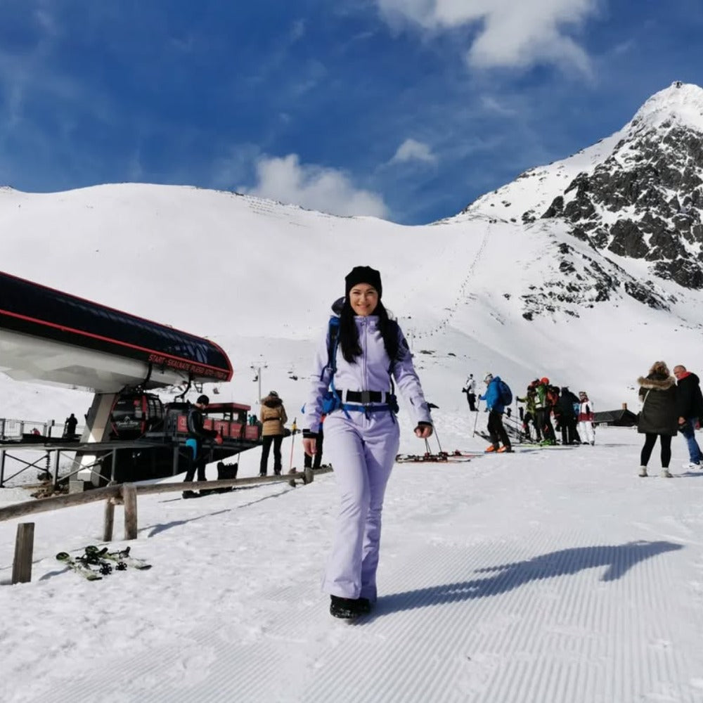 Les Odettes women's classic faux fur one-piece ski suit with hood, waterproof fabric, and insulated design for winter skiing.