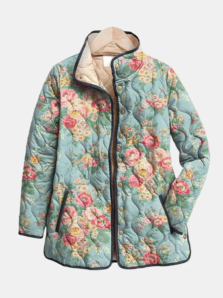 Les Odettes Eliza™ quilted floral print jacket with textured quilting and vibrant flower patterns, displayed on a hanger.