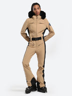 Les Odettes women's classic faux fur one-piece ski suit with hood, designed for winter skiing, in a stylish and warm outdoor setting.
