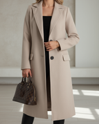Judith™ elegant long coat by Les Odettes featuring a tailored fit, classic collar, and stylish design in neutral fabric.