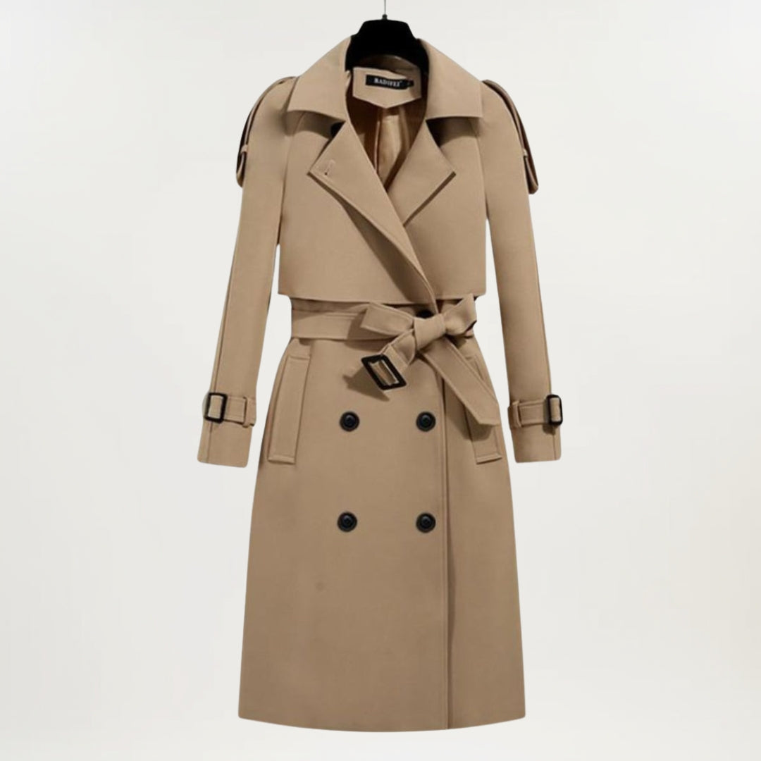 Les Odettes Ashly™ longline trench coat in beige, featuring classic lapels and a belted waist, stylishly displayed on a model.