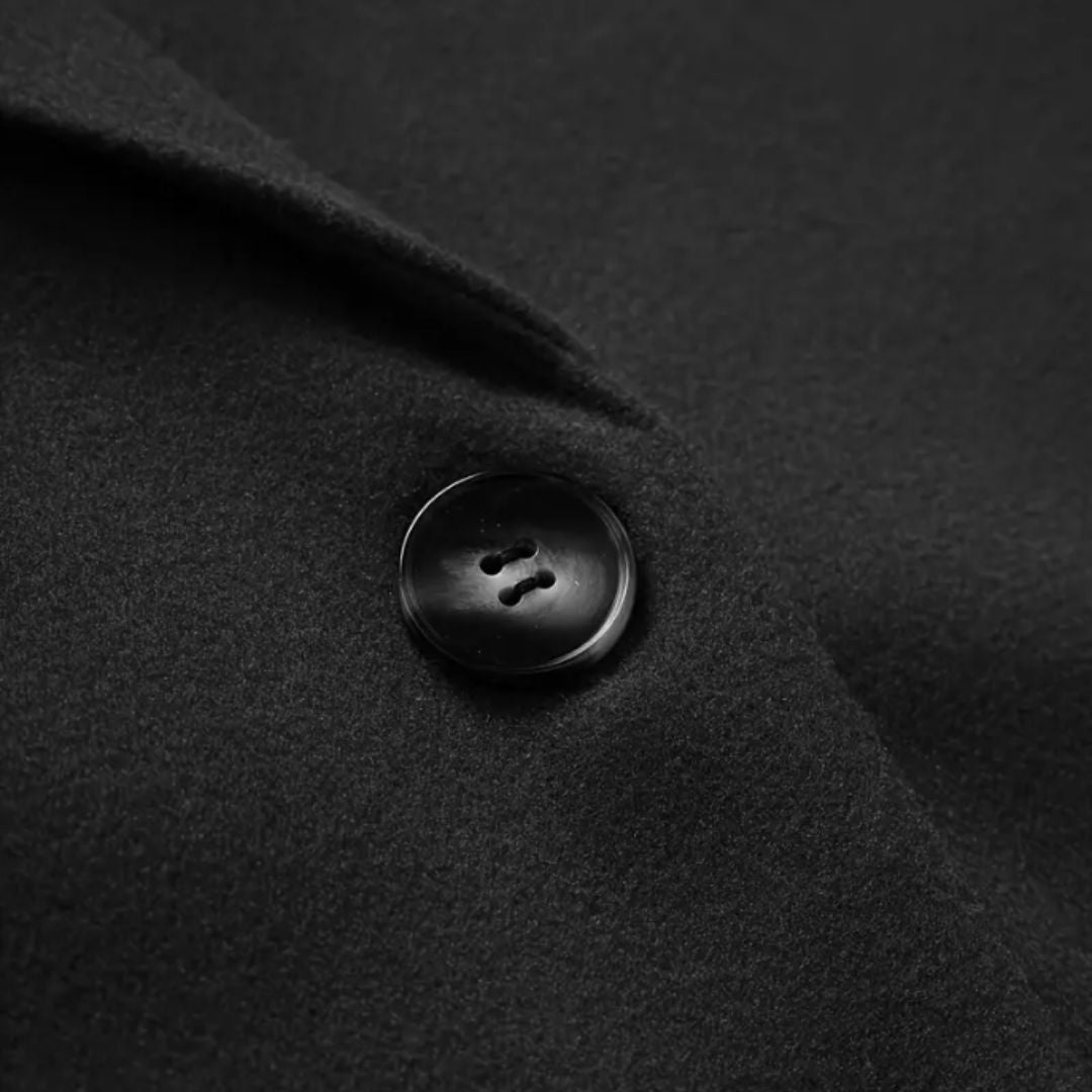 Les Odettes Sally™ longline winter trench coat in neutral fabric, shown on a model with a classic collar and belted waist.