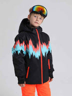 Boy and girl wearing Les Odettes Phibee Lightning Duck Down snow jackets, kids' winter snow jackets with colorful patterns and hoods.
