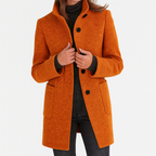 Les Odettes Camila™ timeless women's coat in neutral fabric, stylishly displayed on a hanger.