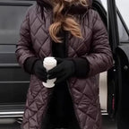 Les Odettes Riley™ quilted coat in navy, featuring a stylish quilted design and classic collar, displayed on a hanger.