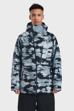 Men's camouflage snow jacket by Les Odettes with face vent, multiple pockets, fully waterproof, designed for winter outdoor activities.