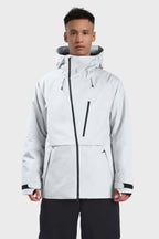 Men's camouflage snow jacket by Les Odettes with face vent, multiple pockets, fully waterproof, grey color, and winter-ready design.