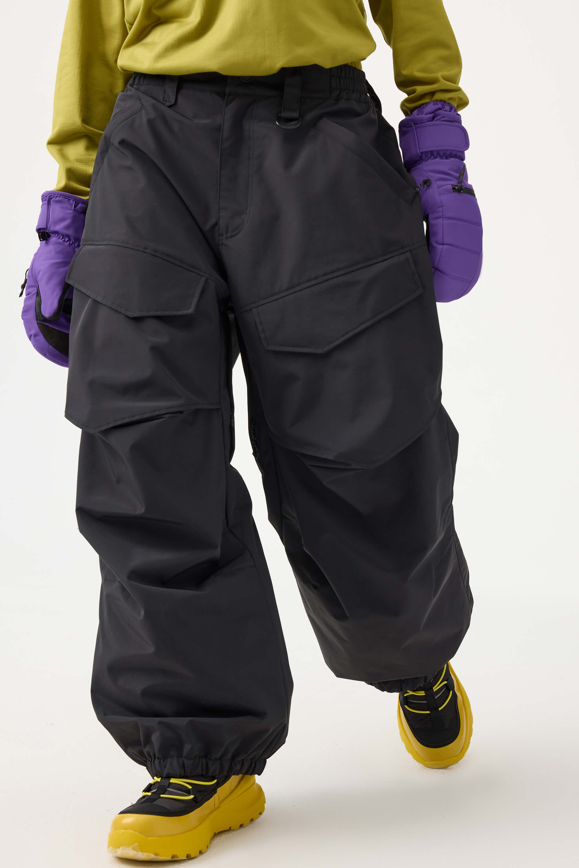 Women's black baggy utility snow pants by Les Odettes with wear-resistant fabric and adjustable waistband, shown on a hanger.