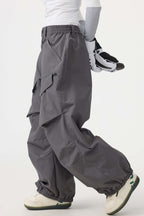 Women's black baggy utility snow pants by Les Odettes, wear-resistant with a loose fit and functional design for winter outdoor activities.