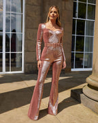 Light Pink sequin jumpsuit for women by Les Odettes, featuring a fitted long sleeve bodice, square neckline, belted waist, and flared leg silhouette, styled in a studio setting for a glamorous evening, party, or formal occasion outfit.