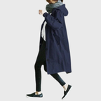 Les Odettes Arline™ waterproof trench coat displayed on a model, featuring a classic design with a belt and button details.