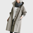 Les Odettes Arline™ waterproof trench coat in classic beige, shown on a model with a belt and double-breasted design.