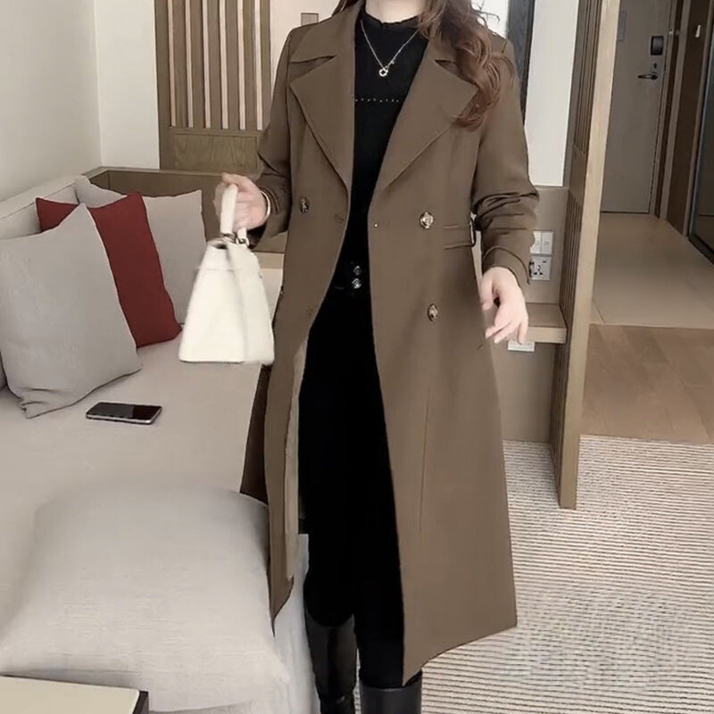 Les Odettes Stella™ sophisticated trench coat displayed on a hanger, featuring classic design with belt and double-breasted style.