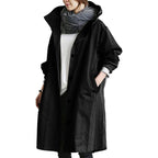 Black women's waterproof raincoat with hood, lightweight design by Les Odettes, shown hanging open with front pockets.