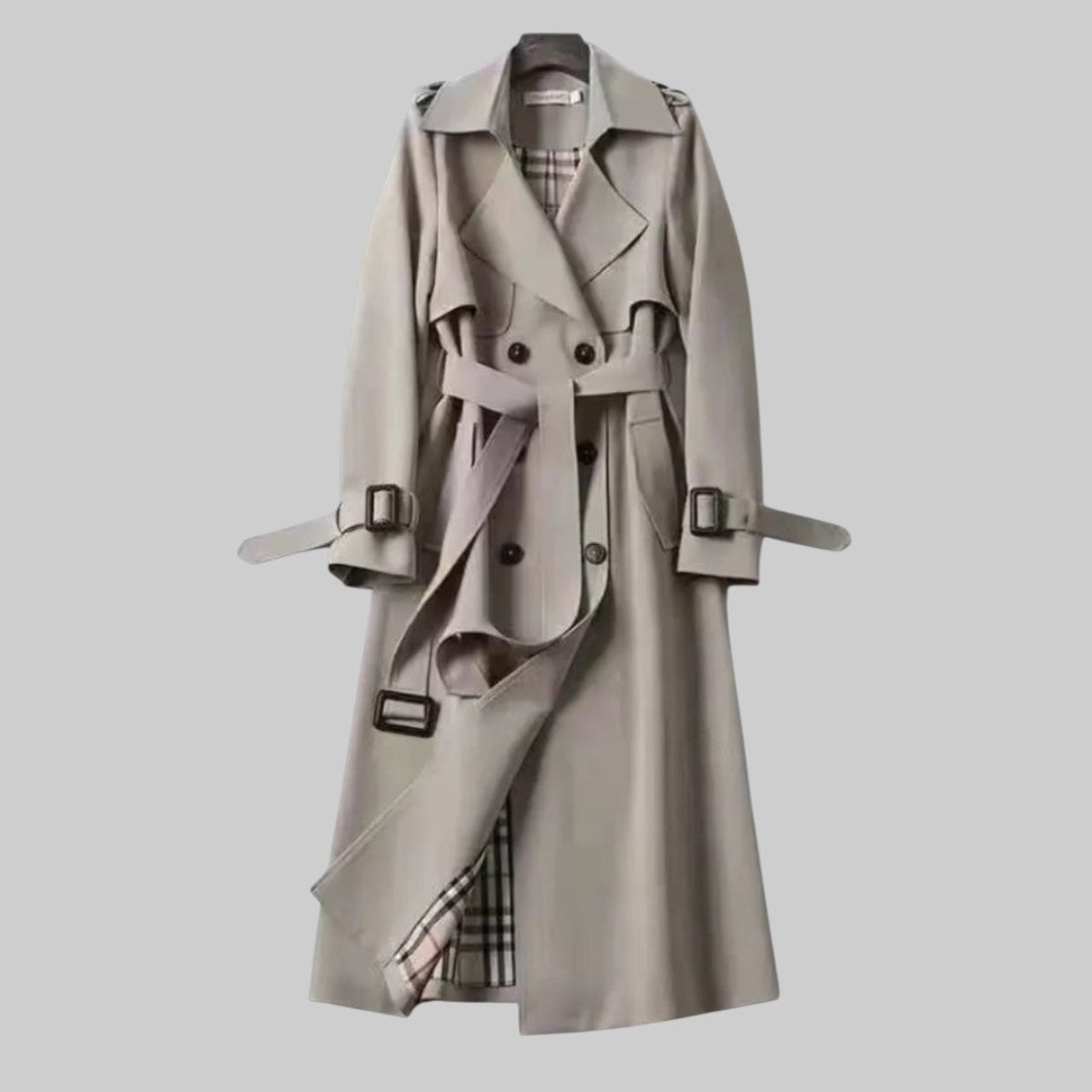 Les Odettes Aleah™ classic trench coat in beige fabric, featuring a double-breasted design and belted waist, displayed on a hanger.