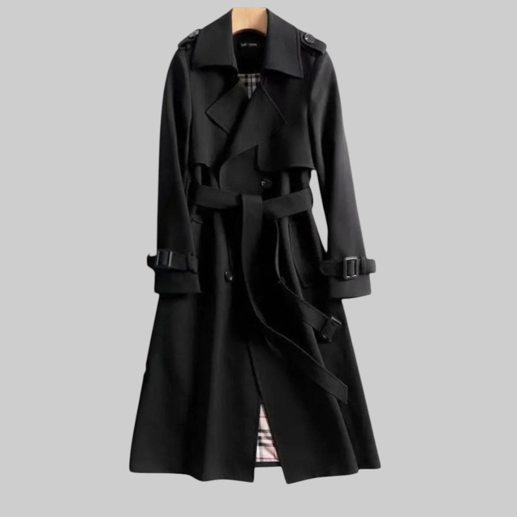 Les Odettes Aleah™ classic trench coat in beige, shown hanging on a wooden hanger with a belt and double-breasted design.