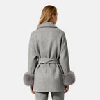 Dark brown mink fur vest by Les Odettes, featuring a sleek zip front and luxurious texture, worn over a gray wool coat with faux fur cuffs.