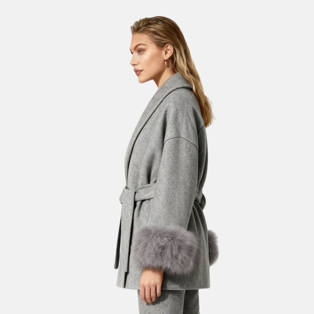 Dark brown mink fur vest with sleek zip front, featuring luxurious texture and stylish design, worn over a gray wool coat with faux-fur cuffs.