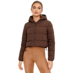 Women’s cropped puffer jacket by Les Odettes, lightweight insulated nylon in chocolate brown, shown on a model.