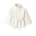 White women's wool blend cape jacket with sculptural design and belt, featuring front view and elegant outerwear style.