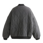 Women's quilted cotton jacket by Les Odettes, oversized charcoal bomber style with lightweight thermal insulation, shown from the back.