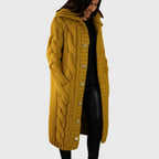 Les Odettes Cadence™ elegant cozy coat displayed on a hanger, showcasing warm fabric and stylish design for winter wear.