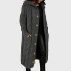 Les Odettes Cadence™ Elegant Cosy Coat displayed on a hanger, featuring a soft fabric and tailored design in neutral tones.